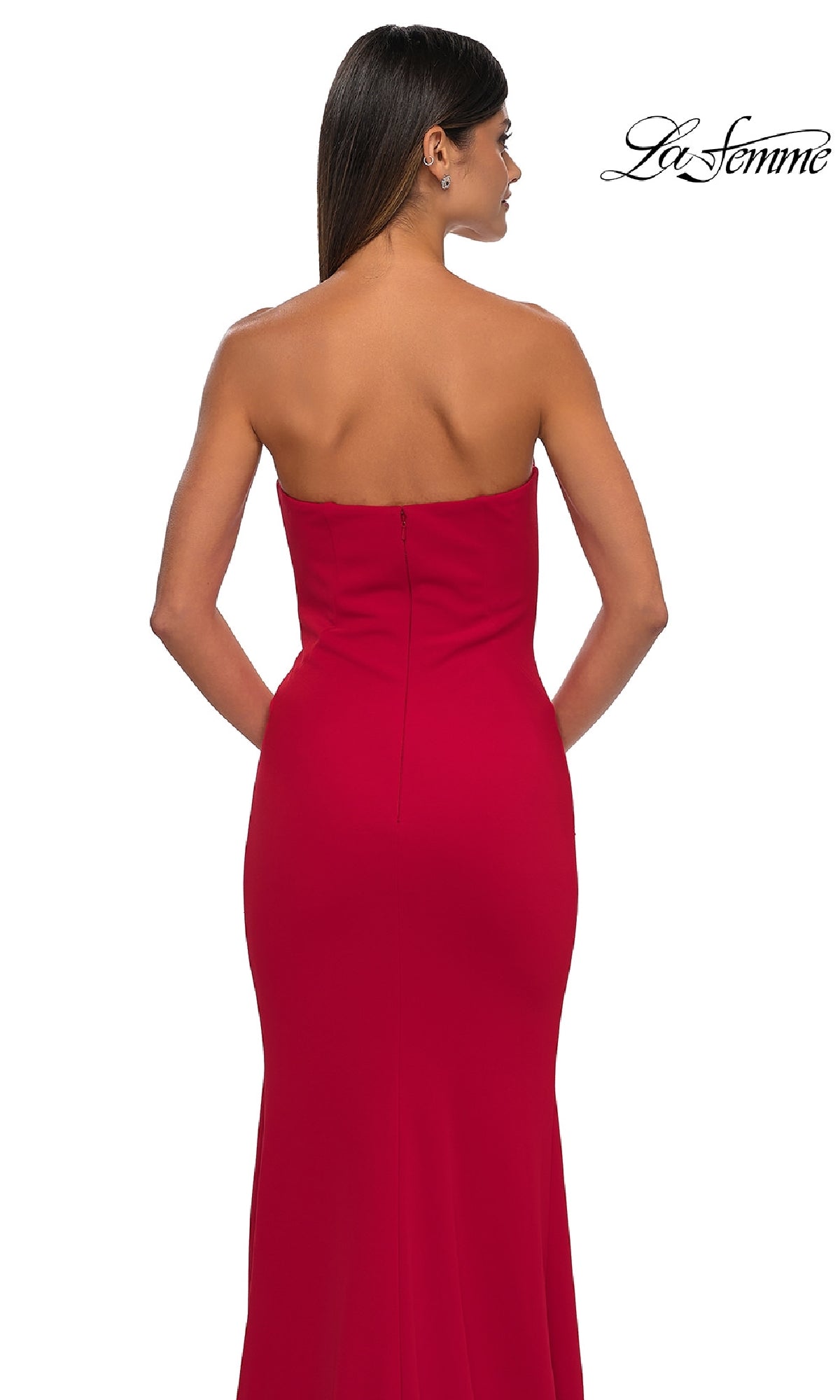 A woman faces away from the camera wearing the Strapless Sweetheart Prom Dress: La Femme 32919 in red, against a white background with the